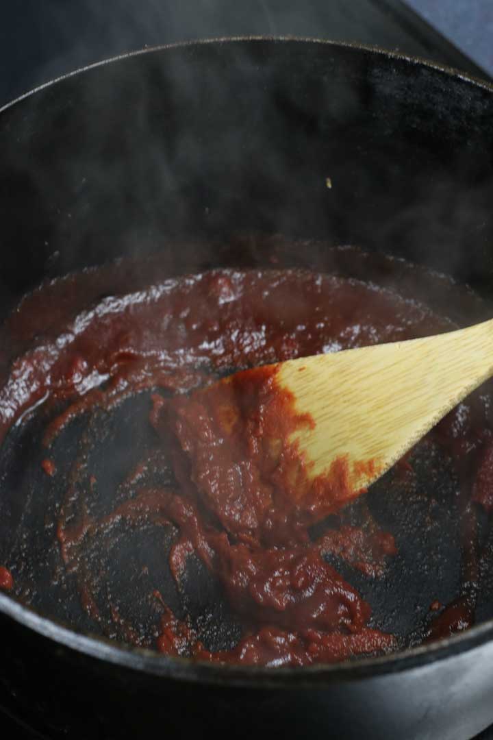 Mixing the red wine and tomato paste together.