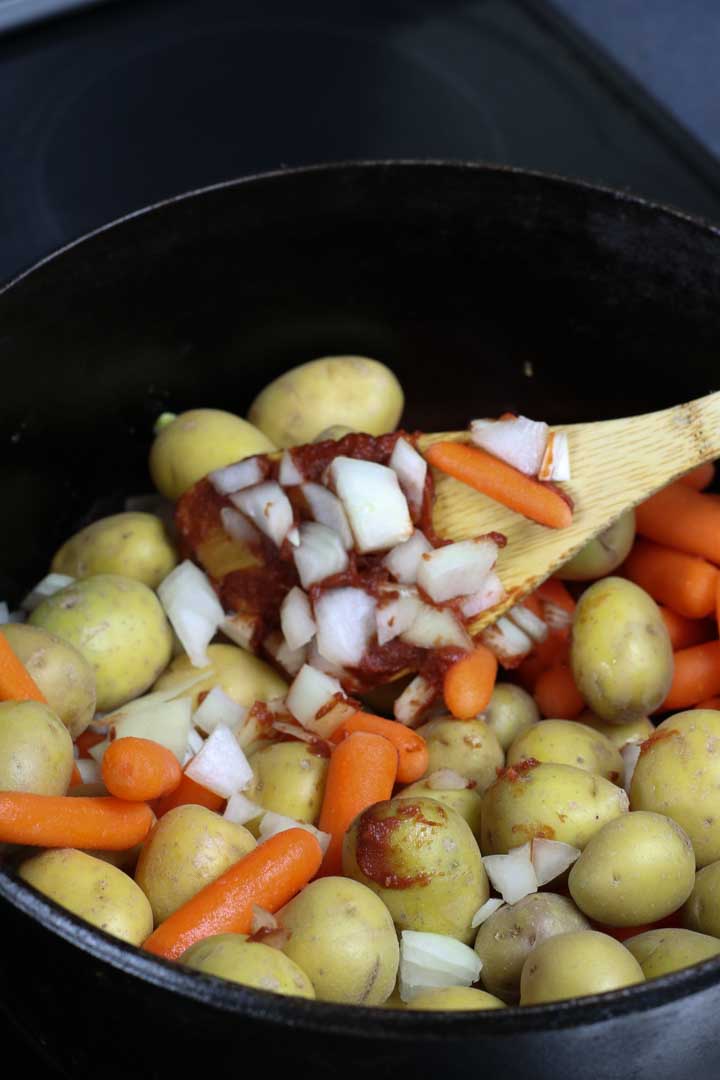Onions, potatoes, and carrots mixed into the pot