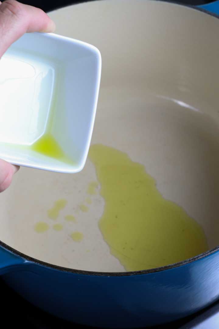 olive oil poured out into a large pot