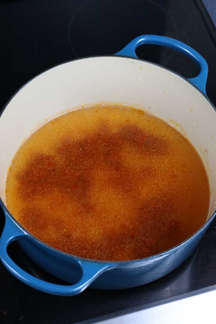 water added to tomato paste in a dutch oven