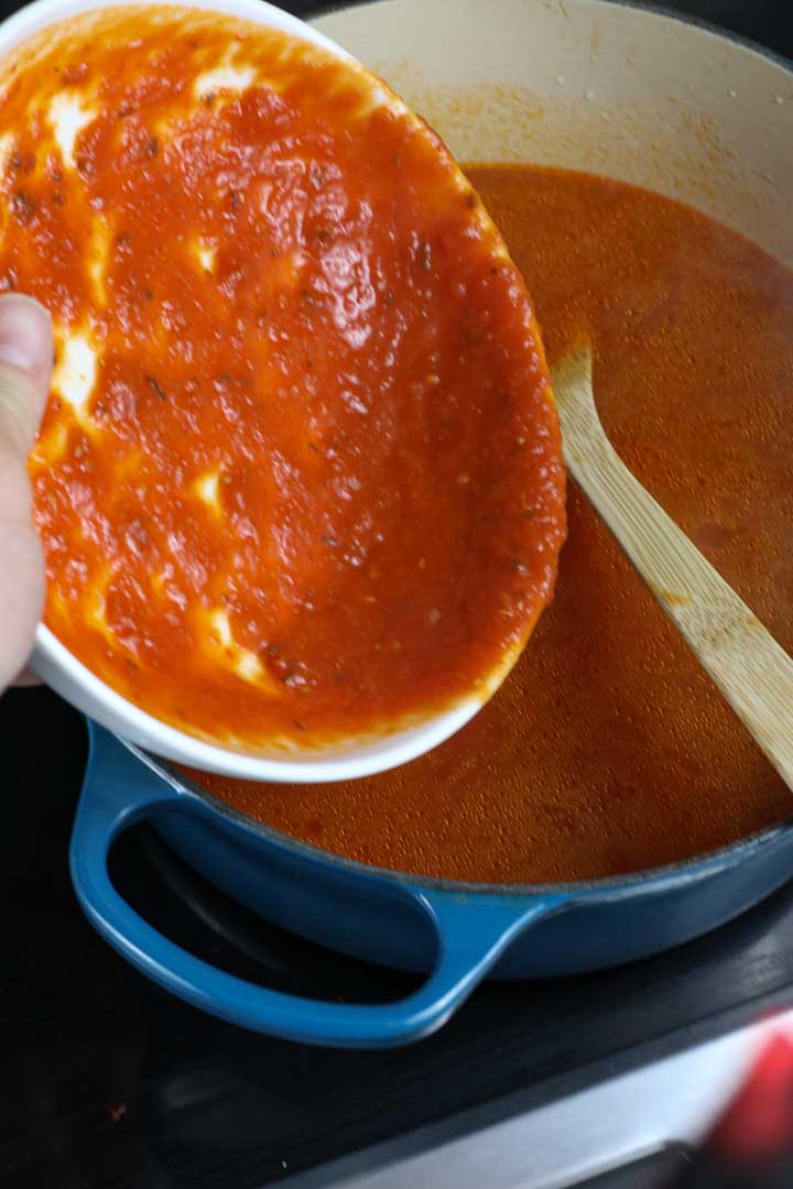 Adding the marinara sauce to the soup
