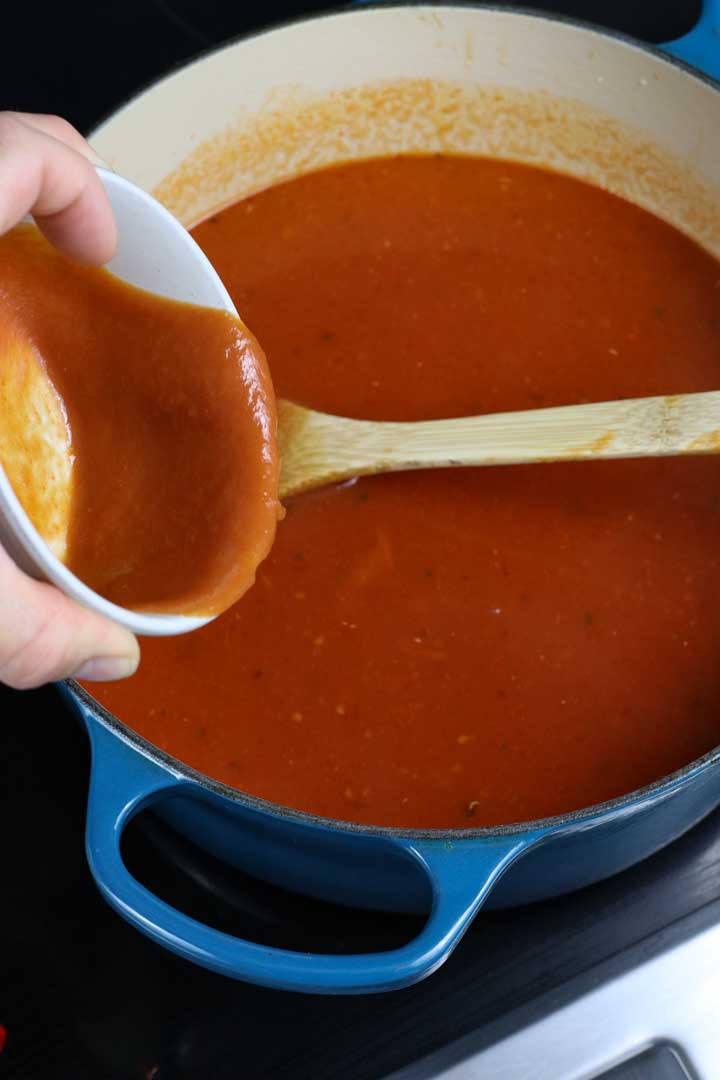 Poured out the tomato soup into the pot.