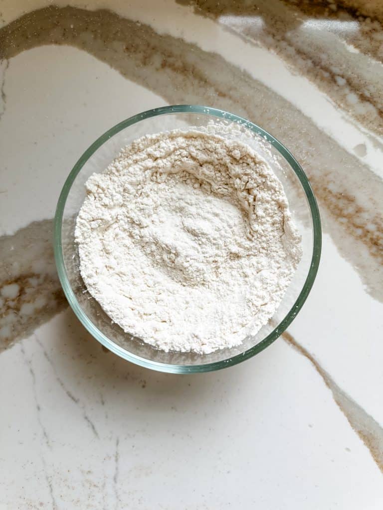 flour, baking soda, baking powder and salt mixed together in a small bowl