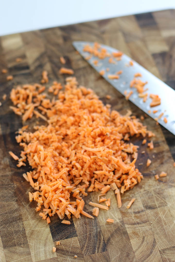 Grated carrots chopped on a cutting board.