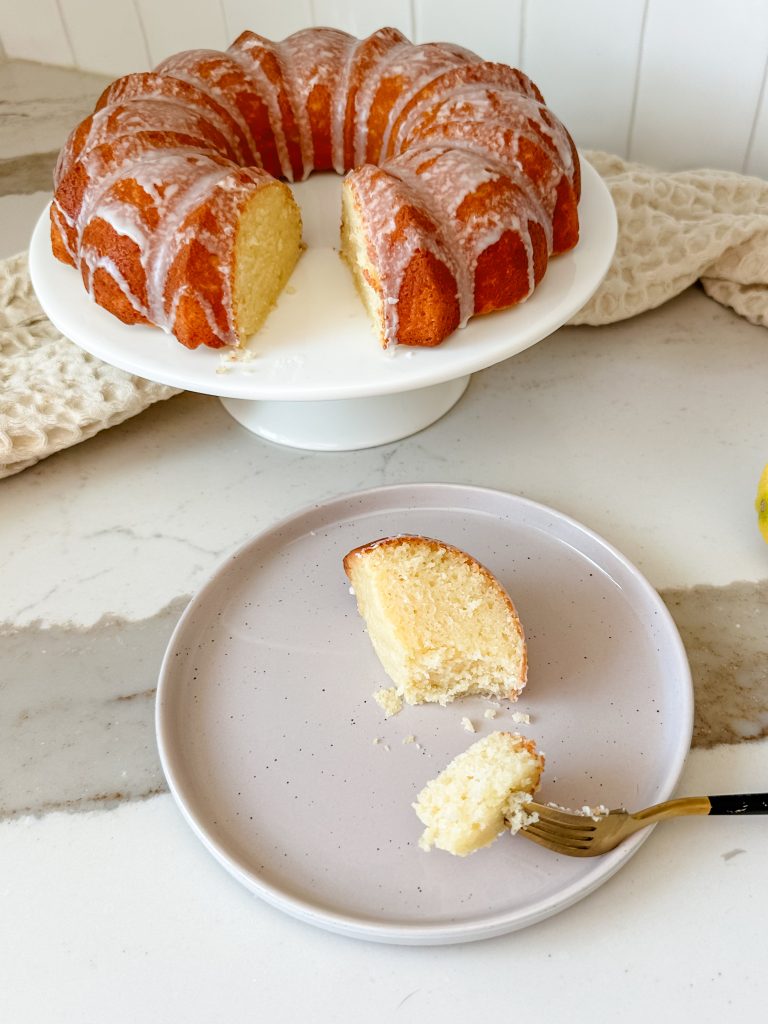 a slice of the lemon cake on a plate with a fork taking a bite. 