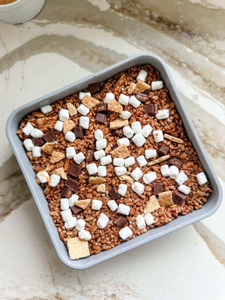marshmallows, graham crackers and chocolate added on top of the cereal mixture