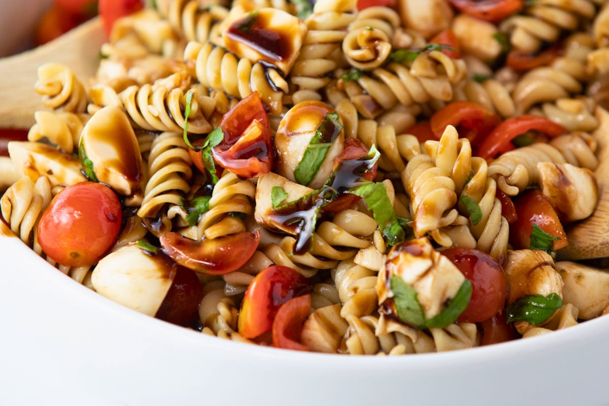 caprese pasta salad with tomatoes, mozzarella cheese, balsamic vinaigrette dressing